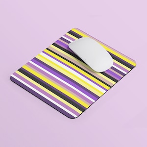 Op de afbeelding: Een muismat met paarse, gele en zwarte strepen met een witte draadloze muis erop.