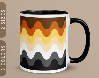 Puede incluir: Una taza de cerámica blanca con asa y borde negros. La taza presenta un patrón ondulado en marrón, naranja, amarillo, blanco, gris y negro.