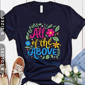 May include: A navy blue t-shirt with a floral design and the text "All of the Above" in colorful lettering.