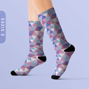 Puede incluir: Un par de calcetines con un patrón geométrico de triángulos rosas, azules y blancos. Los calcetines están hechos de un material suave y cómodo y son perfectos para el uso diario.