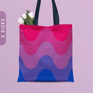 May include: A tote bag with a wavy pattern in shades of pink, purple, blue, and dark blue. The bag has black handles.