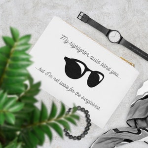 May include: White zippered pouch with the text "My highlighter could blind you... but I'm not liable for the sunglasses." and a black silhouette of sunglasses.