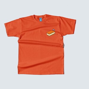 Pu&ograve; includere: T-shirt arancione con una piccola grafica di un panino con una bandiera olandese. La maglietta &egrave; a maniche corte e ha un girocollo.