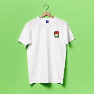 May include: White t-shirt with a small embroidered image of a jar of pickles on the left chest.