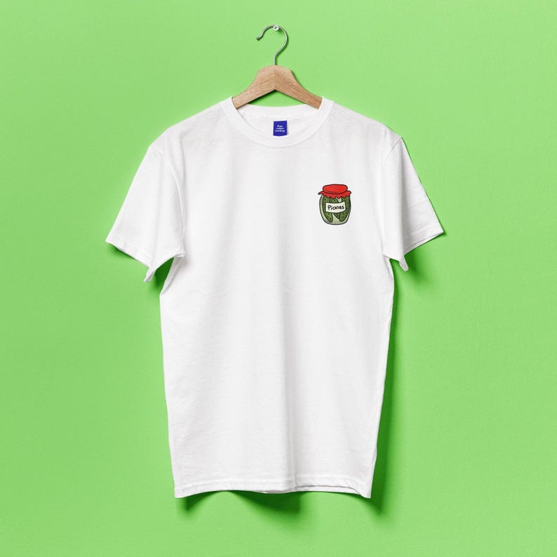 May include: White t-shirt with a small embroidered image of a jar of pickles on the left chest.