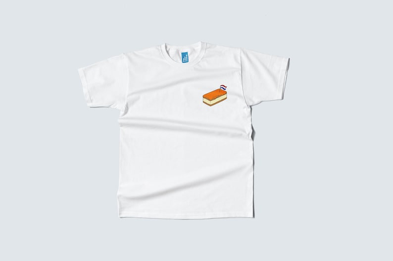 Pu&ograve; includere: T-shirt bianco con una piccola grafica di un dolce olandese, un 'Oliebol', sul petto. Il dolce &egrave; arancione e marrone, con una piccola bandiera olandese. La maglietta ha un girocollo e maniche corte.
