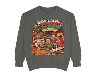 May include: A charcoal grey crewneck sweatshirt featuring a graphic print of three people in pyjamas sitting in front of a Christmas tree with pizza and drinks. The text reads: SAME CREW DIFFERENT PAJAMAS STILL MAKING BAD DECISIONS TOGETHER.