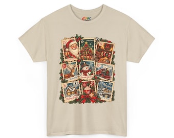 May include: A beige short-sleeved t-shirt featuring a graphic print of nine vintage-style postage stamps depicting holiday scenes including Santa, a Christmas tree, a train, a snowman, and a reindeer, accented with holly and a red bow.