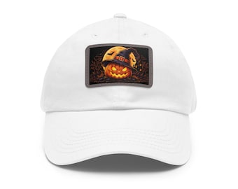 May include: A white baseball cap featuring a rectangular patch on the front. The patch displays a glowing orange jack-o'-lantern wearing a dark witch hat, set against a backdrop of a full yellow moon, flying bats, and dark silhouettes of trees.
