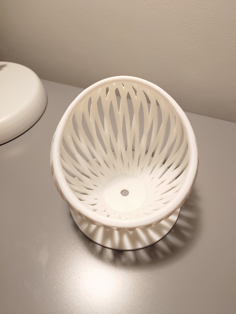 May include: White ceramic bowl with a lattice design. The bowl is on a white base.