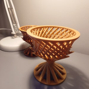 May include: Two brown, 3D printed, decorative bowls with a geometric, lattice design. The bowls are stacked on top of each other.