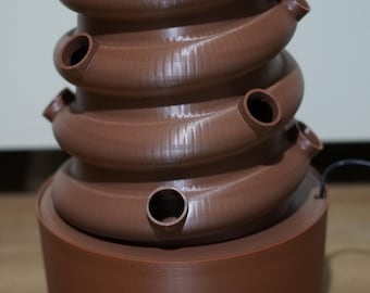 Peut inclure: Un pot de fleurs auto-arrosant en plastique brun avec plusieurs étages et une base ronde. Le pot a plusieurs petits trous pour planter.