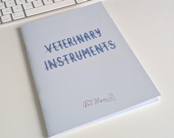 Può includere: Un libretto grigio chiaro con il testo VETERINARY INSTRUMENTS stampato in blu e nero sulla copertina. Sotto il testo, un piccolo logo riporta le parole Vet Nurse Life accanto a un semplice disegno al tratto della sagoma di un cane.
