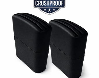 May include: Two black, rectangular objects with a ridged top are displayed against a white background. The objects are positioned side by side. Above them is a shield-shaped emblem with the text "CRUSHPROOF". The emblem has a red, white, and blue color scheme.