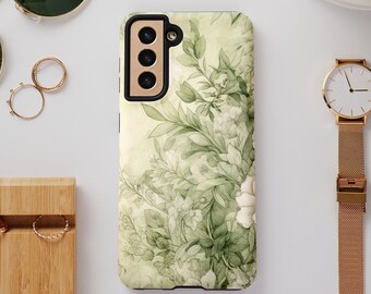 Peut inclure: Une coque de téléphone florale verte et blanche avec une découpe d'appareil photo noire. La coque a un design aquarelle avec des feuilles et des fleurs.