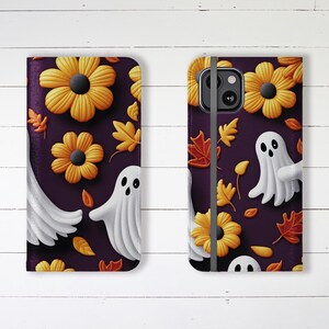 May include: A purple phone case with a Halloween theme. The case features a pattern of orange flowers, white ghosts, and brown leaves.