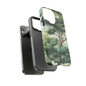 Peut inclure: Un smartphone noir avec une coque de protection repr&eacute;sentant une peinture &agrave; l'aquarelle d'une sc&egrave;ne de for&ecirc;t. L'&eacute;tui est vert et blanc avec un motif d'arbre et de feuillage. Le t&eacute;l&eacute;phone et l'&eacute;tui sont affich&eacute;s sur fond blanc.