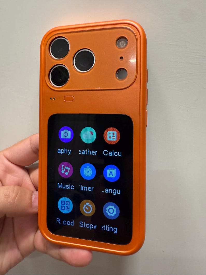 May include: Orange smartphone with a rectangular screen displaying app icons. The phone has a camera array on the top left and a single camera on the top right. The screen displays icons for a camera, weather, calculator, music, timer, language, record, stopwatch, and settings.