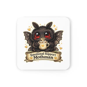 Op de afbeelding: Vierkante witte onderzetter met een cartoon Mothman-personage met grote rode ogen, die een mok warme chocolademelk vasthoudt. De onderzetter heeft de tekst "Emotional Support Mothman" op een banner, omringd door harten en sterren.