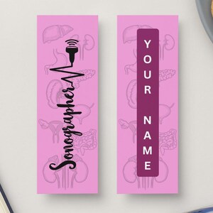 Puede incluir: Dos marcapáginas rosas. Uno presenta un diseño de ecografista negro con una línea de latidos y la palabra "Sonographer". El otro tiene un rectángulo vertical morado con las palabras "YOUR NAME" en blanco.