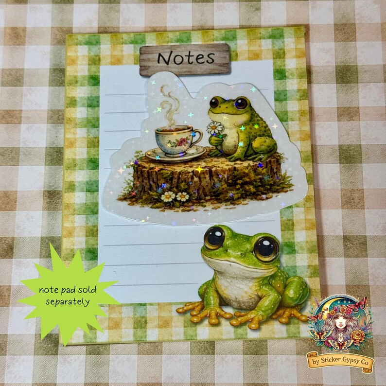 Frog sticker placed on a small gingham notepad labeled “Notes,” featuring a smiling frog illustration below and text indicating notepad sold separately.