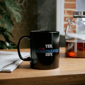 Könnte beinhalten: Schwarze Kaffeetasse mit weißem Text, der "YES. I'M THE GAMECHANGER GUY." lautet.