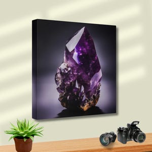 May include: A canvas print of a striking purple amethyst crystal. The crystal is sharply pointed with multiple facets, set against a dark backdrop. The base of the crystal has a rough, textured appearance. The image is well-lit, highlighting the crystal's details.