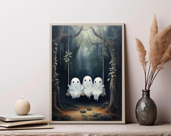 May include: A framed wall art print depicting three white ghosts with simple black eyes and mouths sitting together on a wooden swing suspended by ropes between two dark, mossy trees in a misty forest setting with a soft, earthy ground.