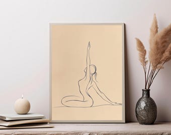 May include: A rectangular wall art print featuring a dark blue continuous line drawing of a person in a seated yoga pose with one arm extended upward, set against a solid light beige background and enclosed in a thin light-colored frame.