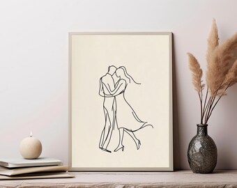 May include: A framed wall art print featuring a black continuous line drawing of two figures embracing and dancing. The artwork is set against a solid cream-colored background, showcasing a fluid and simplified depiction of two people in motion.