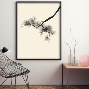 May include: A framed wall art print featuring a black ink illustration of a pine tree branch with needles on a cream-colored background. The artwork is displayed in a thin black frame, showcasing a detailed botanical study of the pine branch.