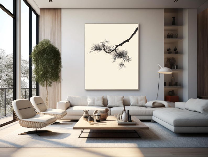 May include: A large rectangular wall art piece featuring a black ink illustration of a pine tree branch with needles against a solid cream-colored background, framed in a thin light-colored wooden frame and mounted on a white wall.