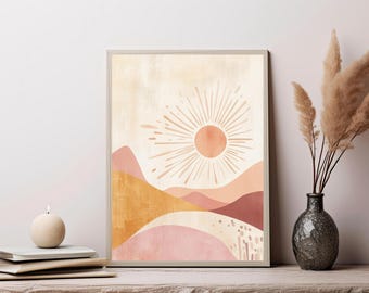 May include: A framed wall art print featuring a stylized sun with radiating lines above layered, abstract hills in shades of terracotta, mustard yellow, and soft pink. The background has a textured, cream-colored wash with subtle vertical brushstrokes.
