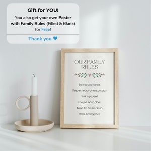 May include: A framed print with the text "Our Family Rules" and a list of rules for family life, including "Be kind and honest", "Respect each other's privacy", "Trust in yourself", "Forgive each other", "Keep the house clean", and "Have fun together". The print is on a white background with a light wood frame and a small heart and green leaves at the top.