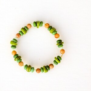 May include: A green and brown beaded bracelet with a gold clasp.