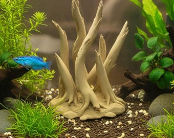May include: An aquarium scene with live fish and plants. A beige, decorative, tree-like structure is in the center. The text at the bottom says, "For Aquarium use, please drill two small holes (1/4 in) on the underside to allow water to flood the model so that it will sink."
