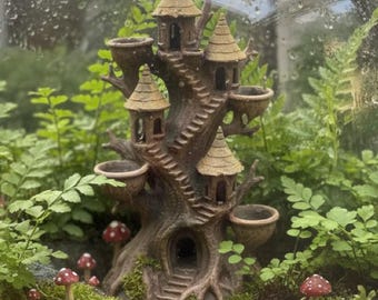 May include: A miniature fairy treehouse with multiple levels, balconies, and a winding staircase. The treehouse is brown with tan-colored roofs and is surrounded by lush green plants and small red and white mushroom figurines. The text at the bottom reads: "For Terrarium use, please keep the model from direct contact with heat lights."