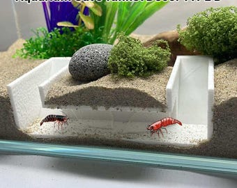 May include: White aquarium cave tunnel decor with a gray rock and green plants. The text "Aquarium Cave Tunnel Décor TYPE B" is at the top. Two red shrimp are in the aquarium. The bottom of the image has the text "png image from vhv.rs".