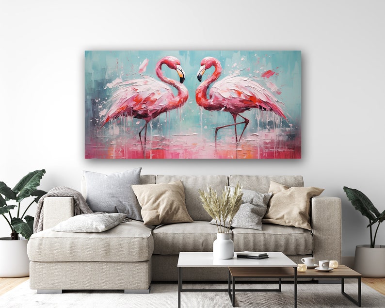 May include: A painting of two pink flamingos standing in a shallow body of water. The flamingos are facing each other and their necks are curved in a heart shape. The background is a light blue with splashes of pink and white paint.