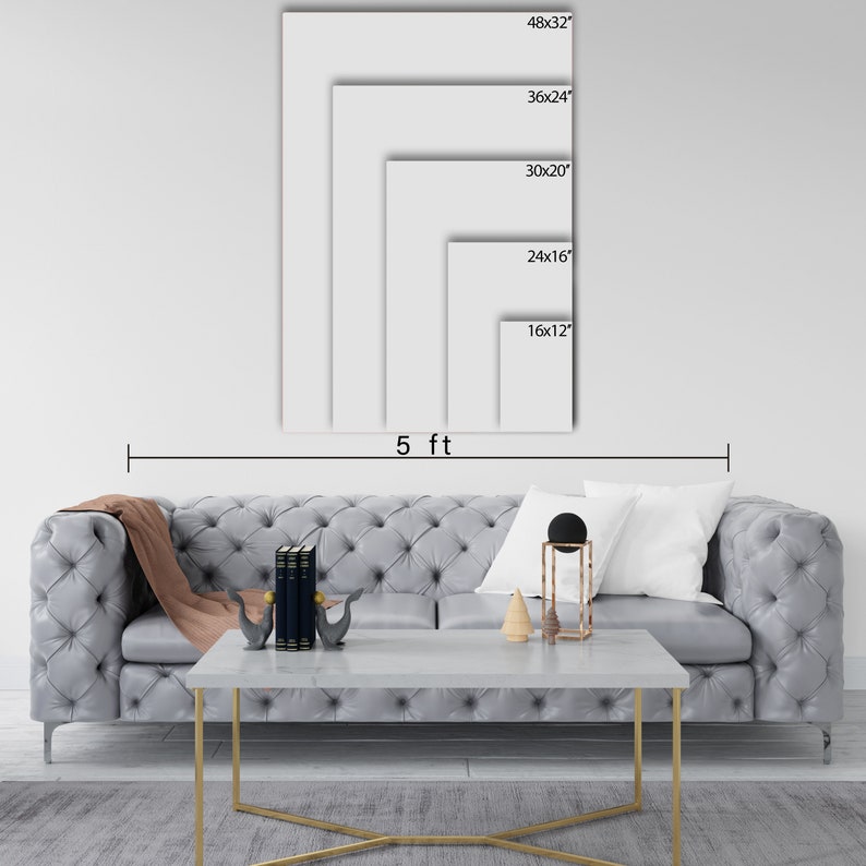 May include: A white wall with a gray couch and a coffee table in front of it. The wall has five different sized white frames with black text indicating the dimensions of each frame in inches. The text reads: 48x32, 36x24, 30x20, 24x16, 16x12. The text "5 ft" is written below the frames.