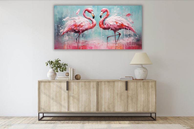 May include: A painting of two pink flamingos standing in a shallow body of water. The flamingos are facing each other and their necks are curved in a heart shape. The background is a light blue with white splashes of paint.