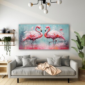 May include: A painting of two pink flamingos standing in a shallow body of water. The flamingos are facing each other and their necks are curved in a heart shape. The background is a light blue with splashes of pink and white paint.