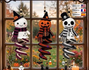 May include: Three crocheted Halloween hanging decorations featuring a ghost, a pumpkin, and a skeleton. Each figure wears a hat and a scarf, with a spiral tail extending downward adorned with small charms like bats, spiders, and skulls, suspended by wooden beads.