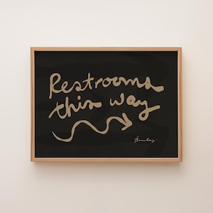 Restrooms This Way - Hand-lettered navigational sign, right. Cream on black.