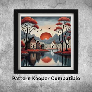 Op de afbeelding: Ingelijste kunstdruk met een serene landschap met huizen, bomen en een meer dat de zonsondergang weerspiegelt. Het kunstwerk heeft een zwarte lijst en de tekst "Pattern Keeper Compatible" onderaan.