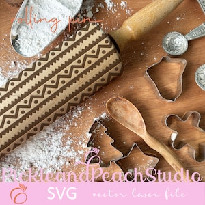 May include: A wooden rolling pin with a brown geometric pattern, surrounded by cookie cutters, a wooden spoon, and powdered sugar on a wooden surface. The text "Pickle and Peach Studio SVG vector laser file" is visible at the bottom of the image.