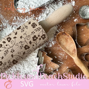 May include: A wooden rolling pin with a floral design. The rolling pin is on a wooden surface with flour scattered around it. There are also cookie cutters and a wooden spoon in the image. The text "rolling pin" is written in the top left corner of the image. The text "Pickle and Peach Studio" is written in the bottom right corner of the image. The text "SVG vector laser file" is written in the bottom center of the image.