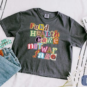 Top court carré Fund Healthcare Not Warfare, chemise anti-guerre, t-shirt FDT avec lettres de magazine