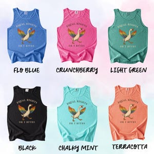 Puede incluir: Seis camisetas sin mangas en varios colores: azul, rosa, verde, negro, turquesa y naranja. Cada camiseta presenta un gr&aacute;fico de un ganso con alas de arco&iacute;ris y el texto "EQUAL RIGHTS OR I BITES". Las camisetas est&aacute;n etiquetadas como "FLO BLUE", "CRUNCHBERRY", "LIGHT GREEN", "BLACK", "CHALKY MINT" y "TERRACOTTA".