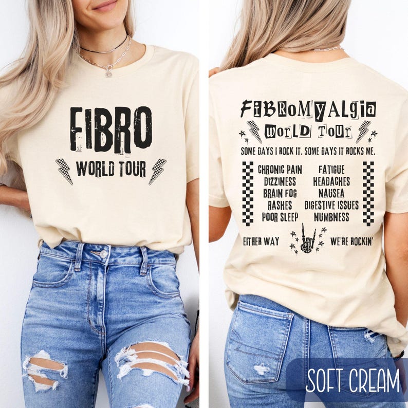 May include: A light beige t-shirt with black text that reads "FIBRO WORLD TOUR" on the front and "FIBROMYALGIA WORLD TOUR" on the back. The back also includes a list of symptoms associated with fibromyalgia, including chronic pain, fatigue, dizziness, headaches, brain fog, nausea, rashes, digestive issues, poor sleep, and numbness. The text on the back also includes the phrases "Some days I rock it. Some days it rocks me." and "Either way we're rockin'."